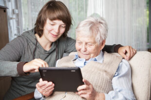 young woman and senior woman using digital tablet