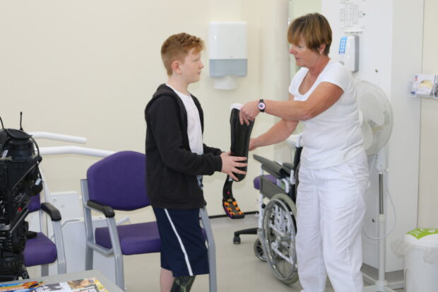 Ben, 13, receives his running blade from prosthetist Clare Johnson 